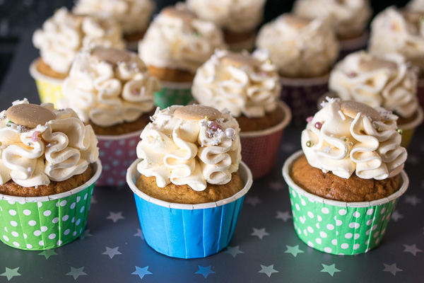Butterbeer cupcakes covered with sprinkles and topped with a Caramac button