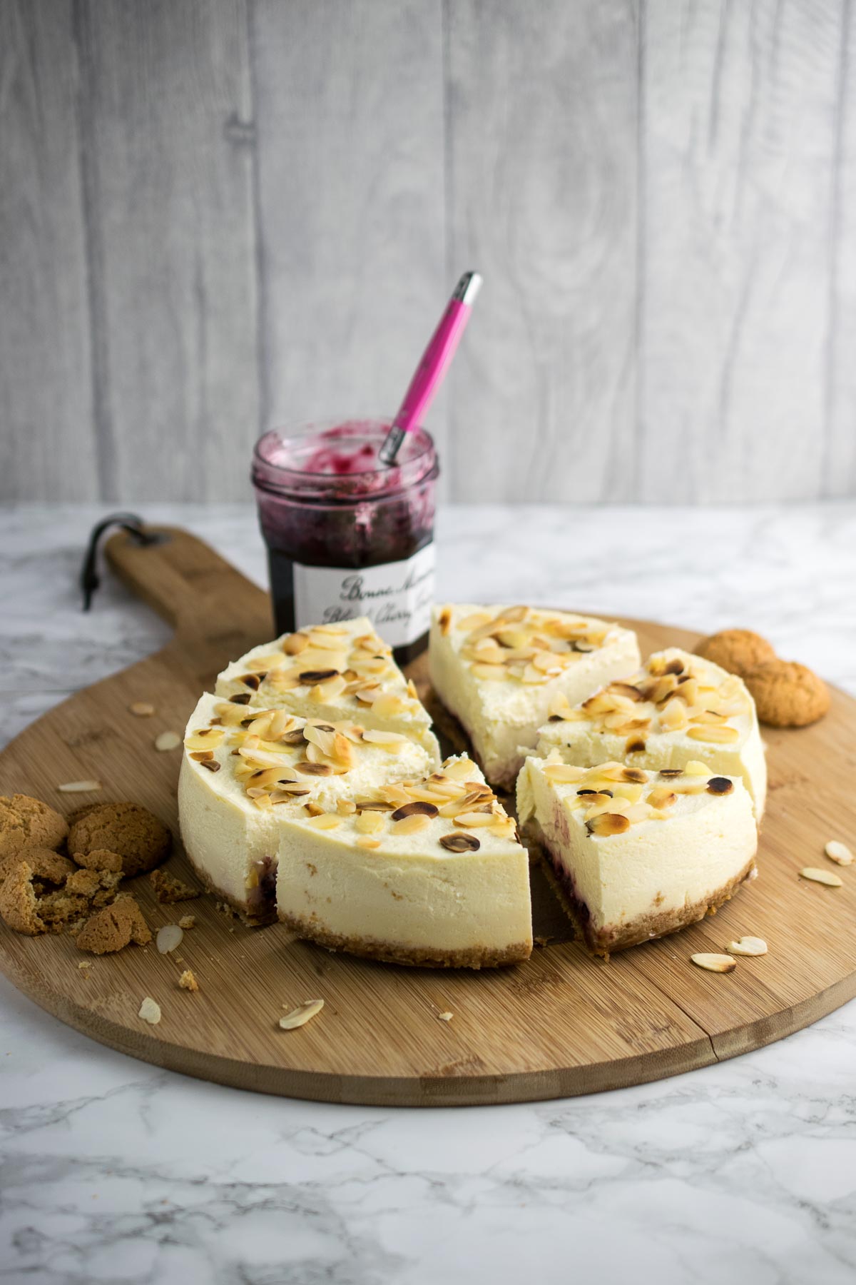 Instant Pot Bakewell Cheesecake. Amaretti and digestive biscuit base with cherry conserve, almond flavoured cheesecake topped with toasted flaked almonds.